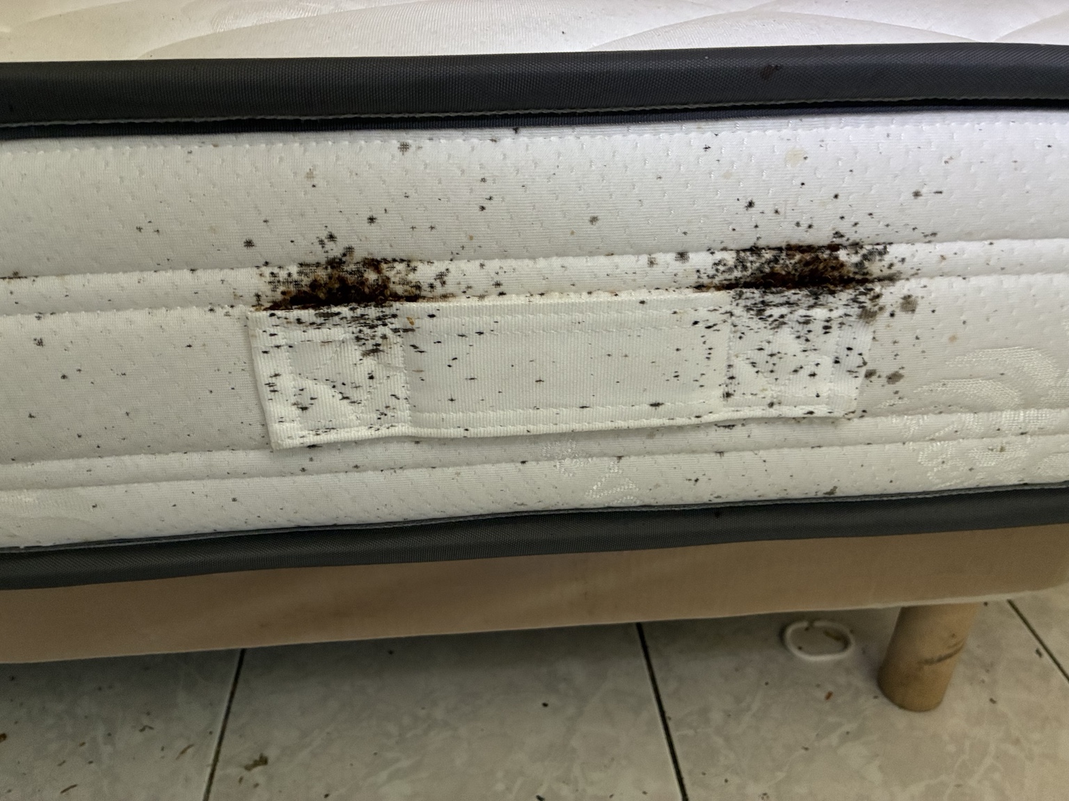 Traces sombres et regroupements sur le côté du matelas.
